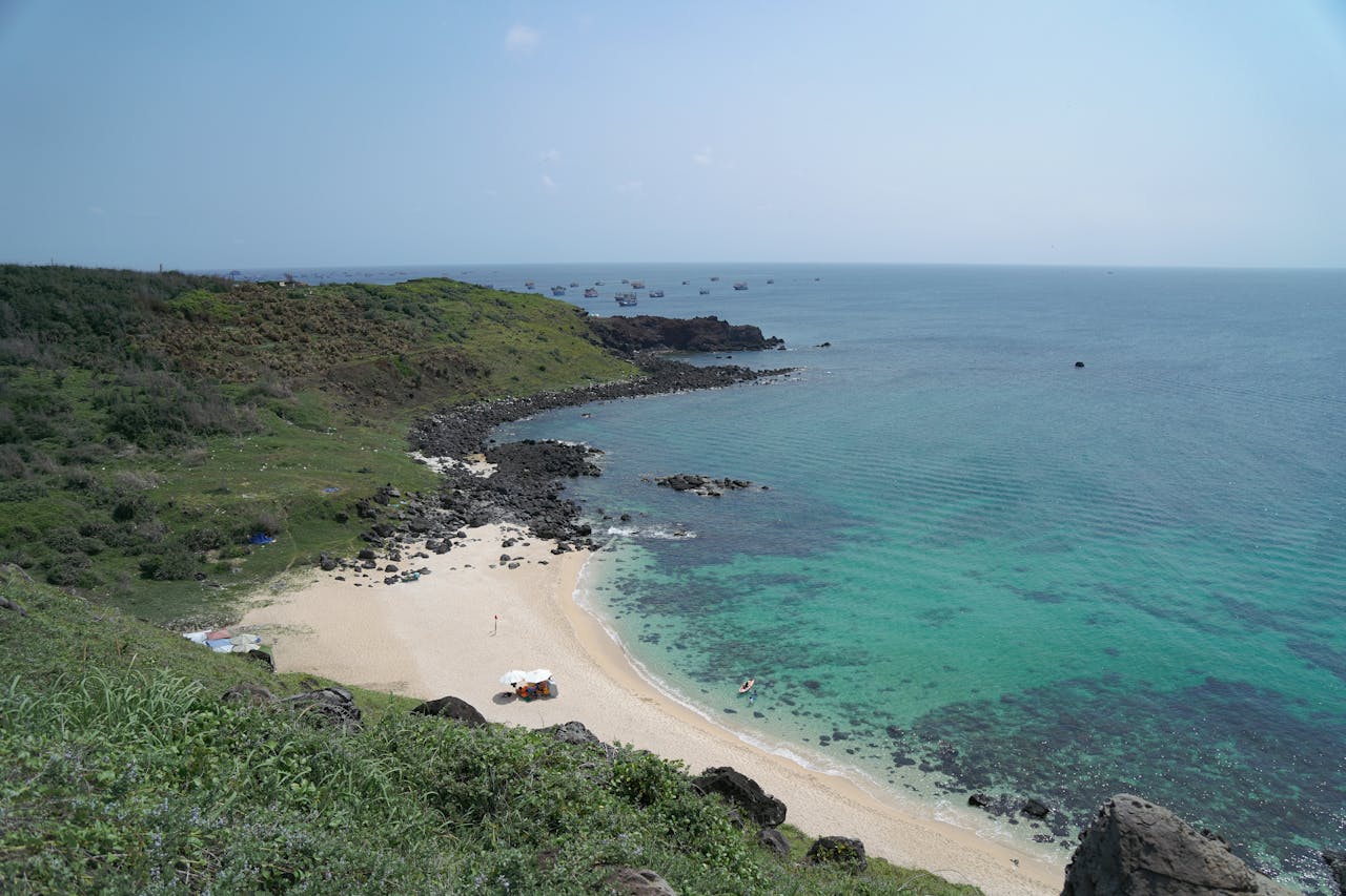 Aerial view of a serene beach and turquoise ocean in Phan Thiết, Vietnam.