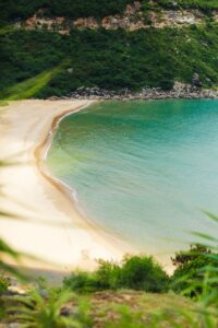 A serene tropical beach with turquoise waters and lush greenery in Phú Yên, Vietnam.
